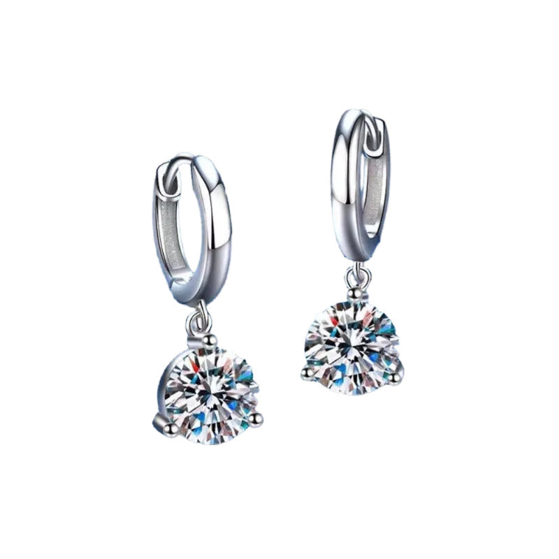 A pair of silver earrings with a large, clear gemstone set in the center.