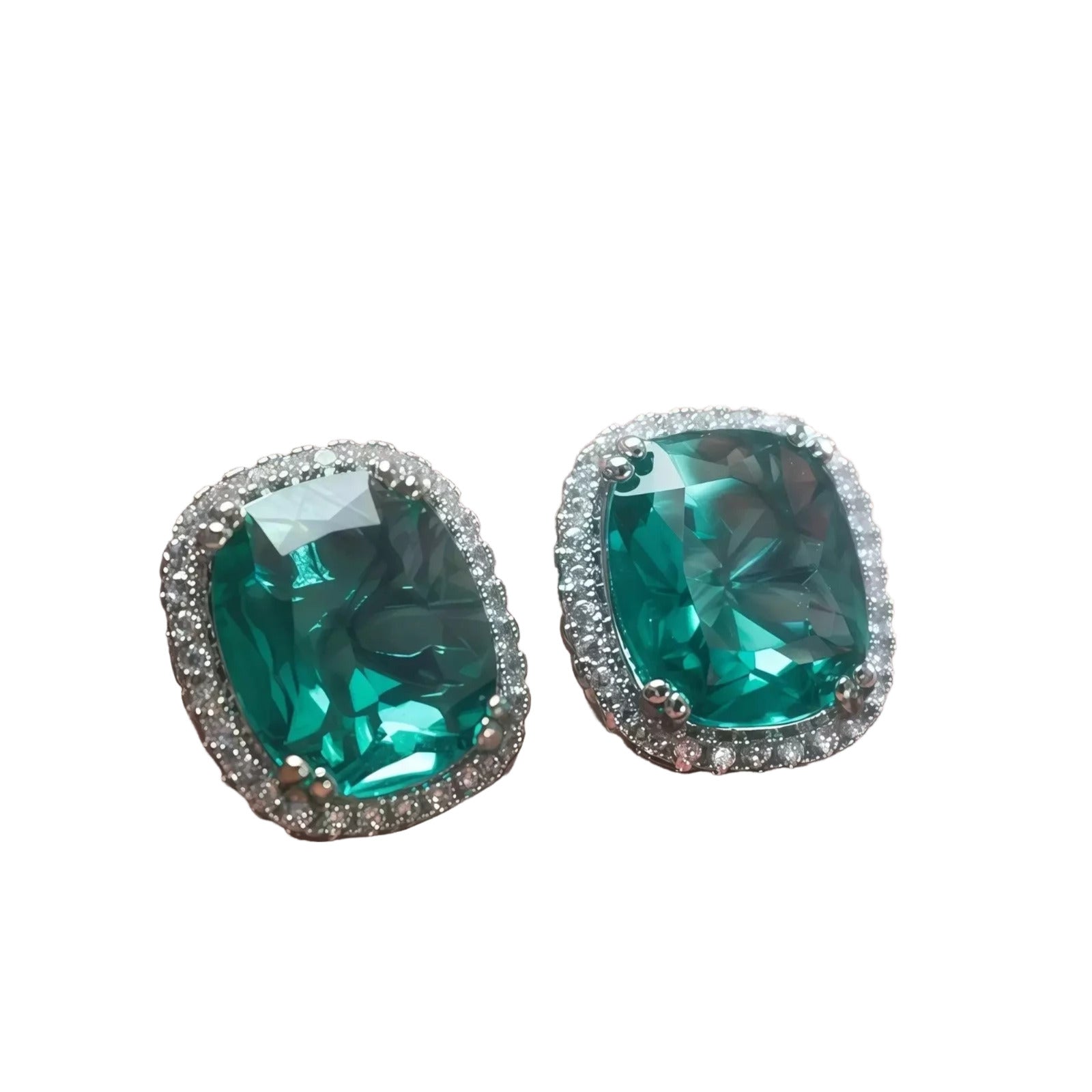 A pair of large, green gemstone earrings with a sparkling crystal border.